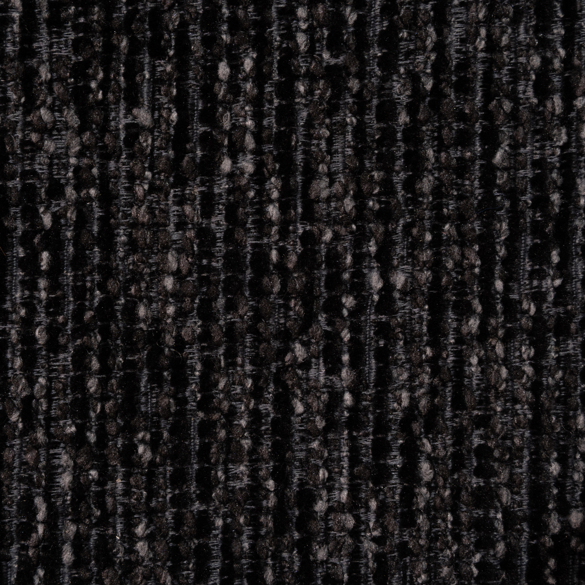 A close-up of a dark textured fabric with vertical ribbed stripes in black, charcoal gray, and subtle warm taupe-brown tones.