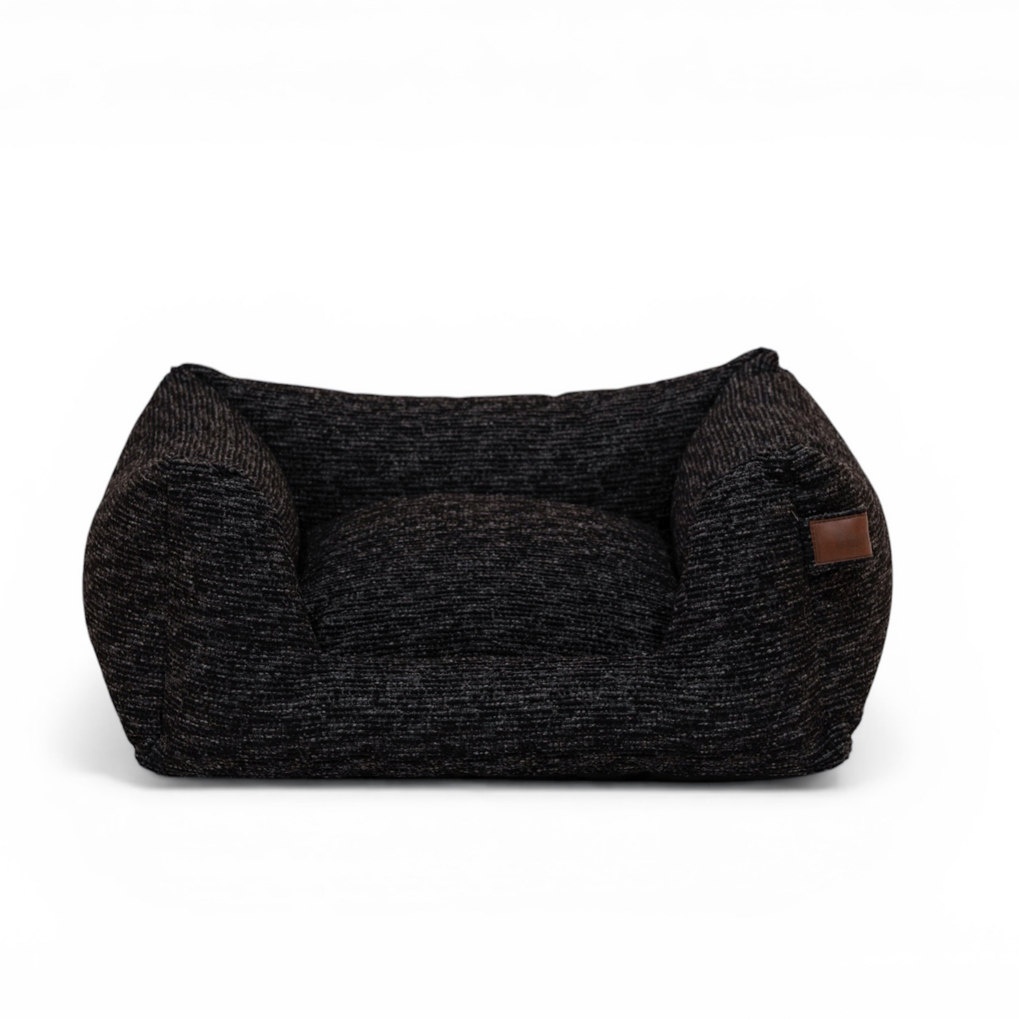 A dark charcoal gray and black textured pet bed with a small brown leather patch on the side, shown against a plain white background.
