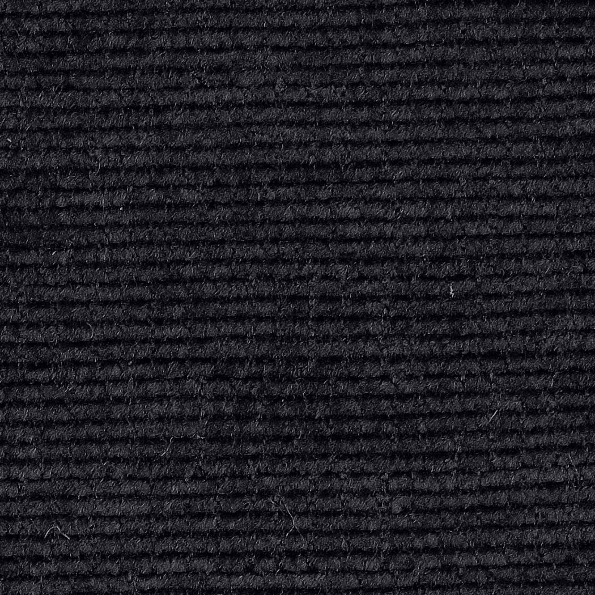 A close-up of a black ribbed fabric texture, showing horizontal corduroy-like ridges..