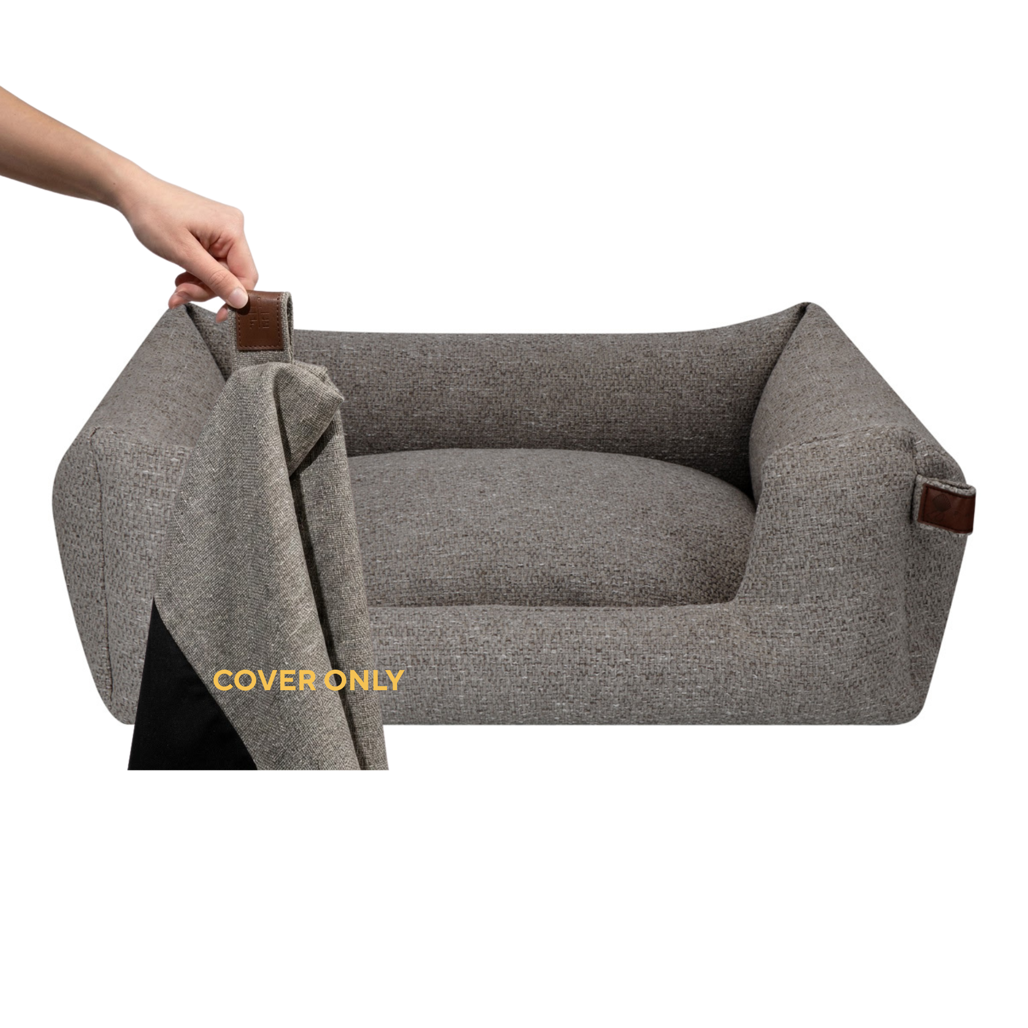 A gray textured pet bed with a raised cushioned interior and brown leather-like corner tabs, shown on a white background. A human hand is lifting the cover on the left, and yellow text reads 'COVER ONLY'.