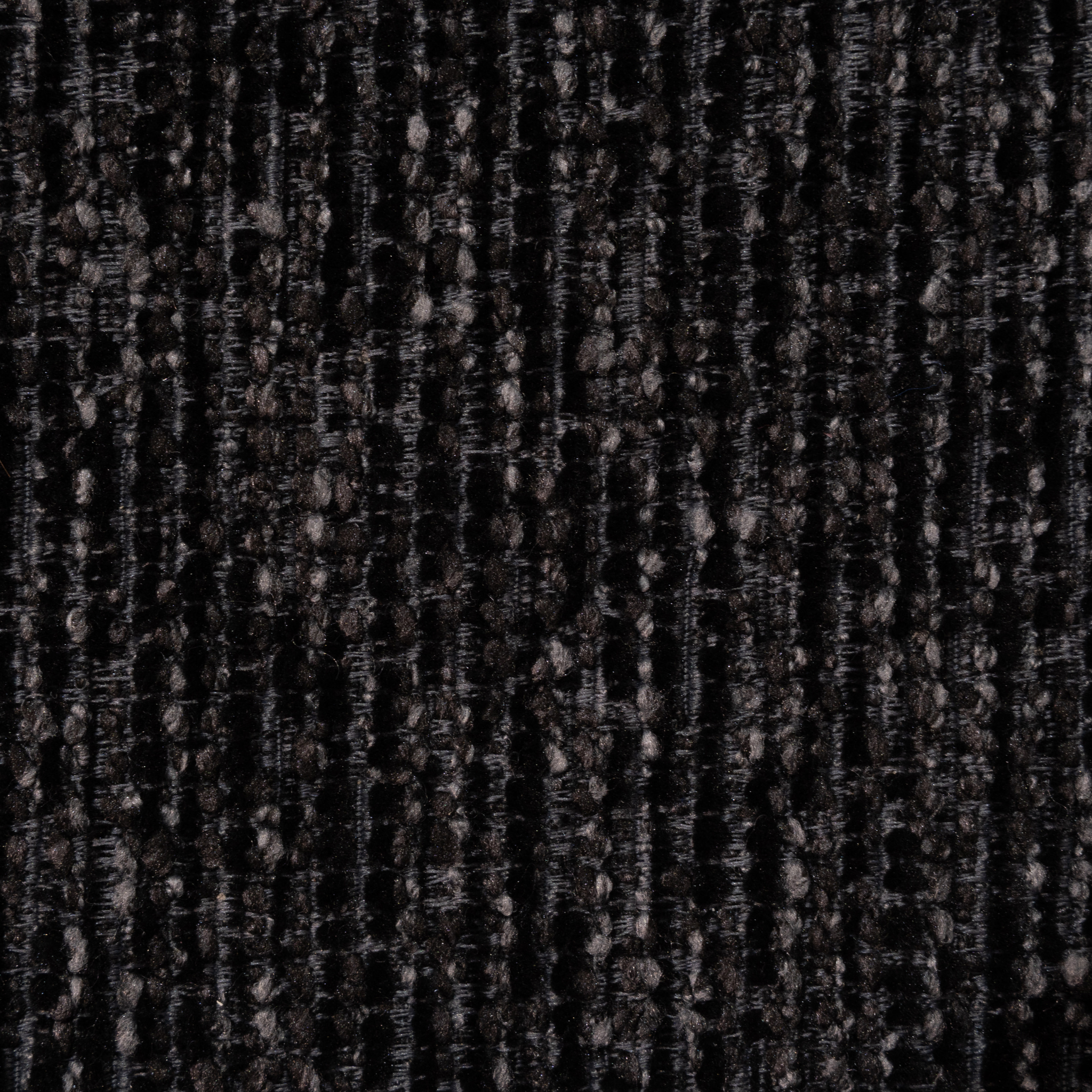A close-up of a dark woven fabric texture with vertical ribbed stripes in black, charcoal gray, and subtle brownish-gray flecks.