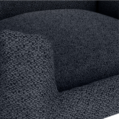 Close-up of a dark charcoal gray textured fabric armchair cushion and armrest.
