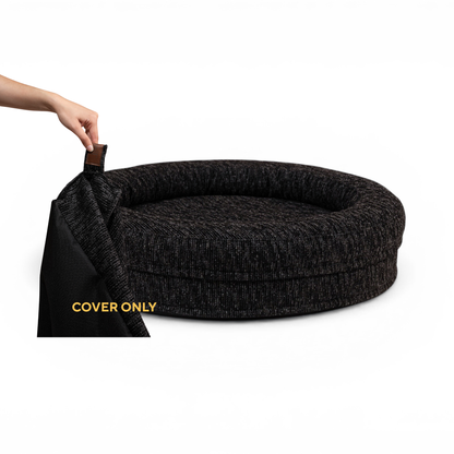 A hand lifting the removable cover off the round Swirl dog bed in Coal Grey, labelled Cover only 